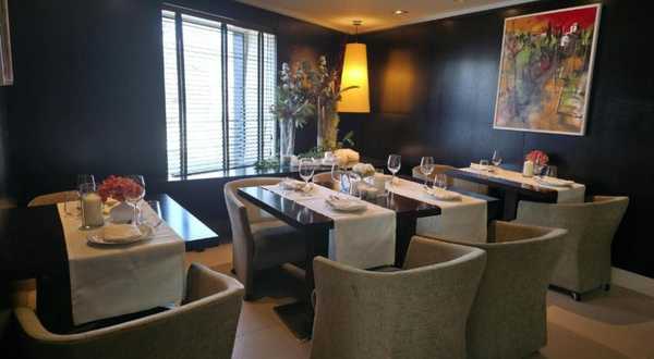 Restaurant with laid tables and grey armchairs at CH Bucharest hotel